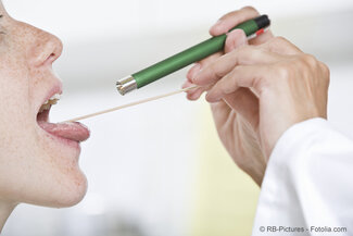 Arzt blickt Patientin in den Rachen